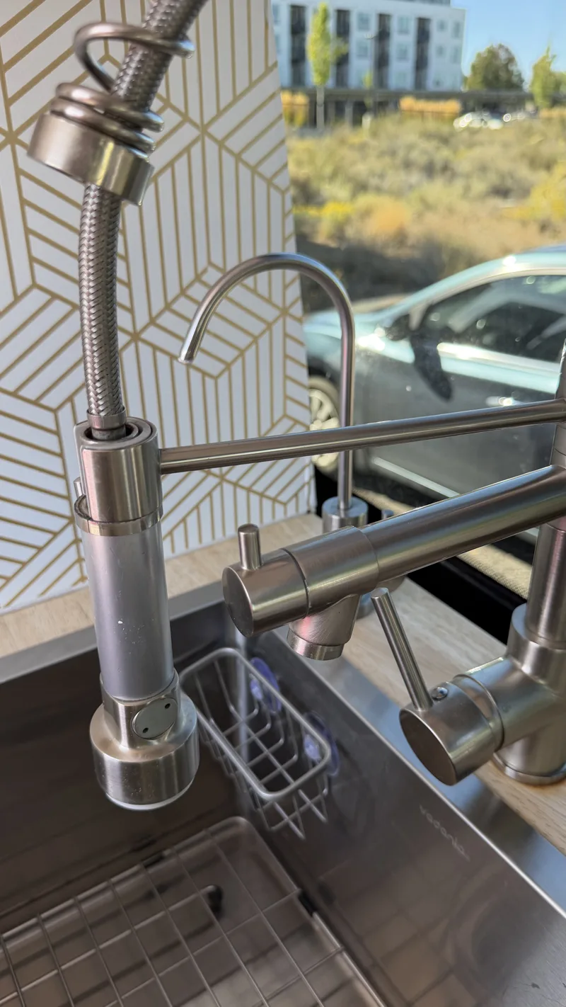 Close-up of Pebbles’ spring-coil kitchen faucet and smaller tap