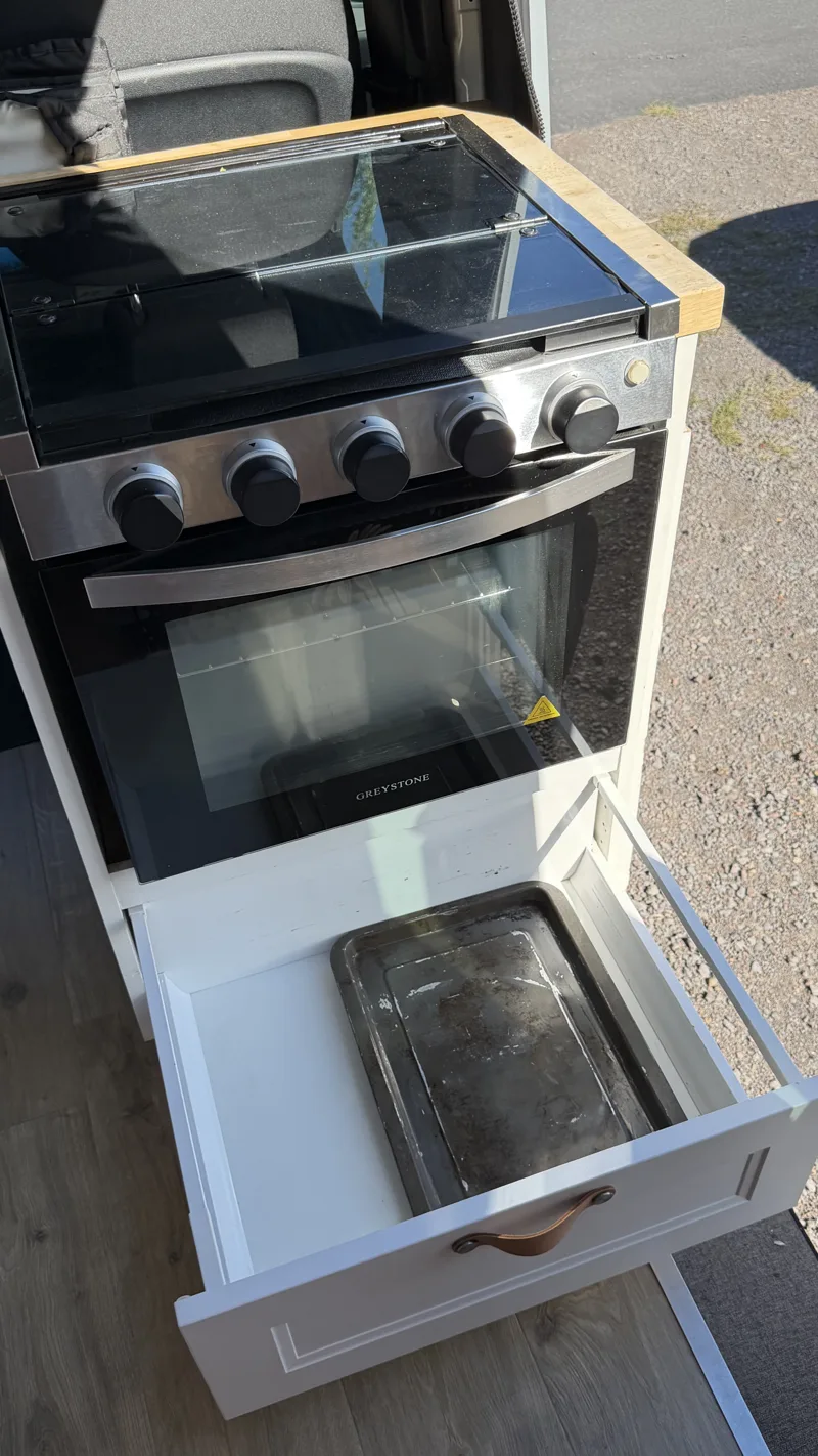 Pebbles’ oven and stovetop with the storage drawer pulled open underneath